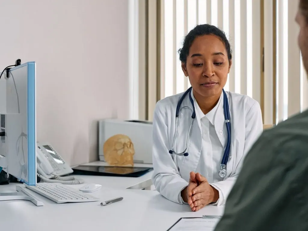 Médecin en consultation face à une patiente, dans son cabinet