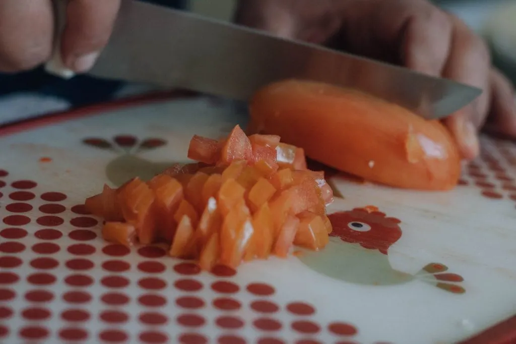 Asperges vertes coupées près d'un couteau sur planche en bois, vue du dessus, sobre