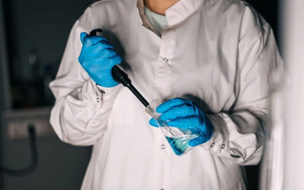 Technicien de laboratoire manipulant une pipette pour une analyse sanguine