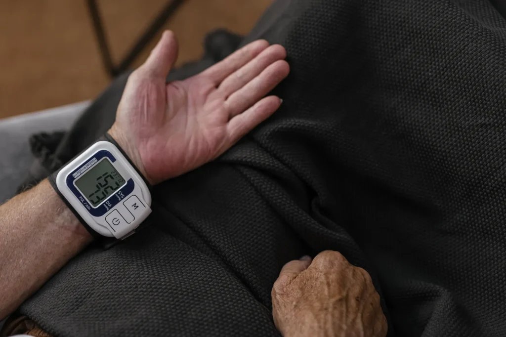 Un adulte senior utilise un tensiomètre au poignet à domicile pour surveiller sa santé